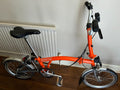 Brompton M3L Superlight Titanium  3 Speed in orange with front Ortlieb bag