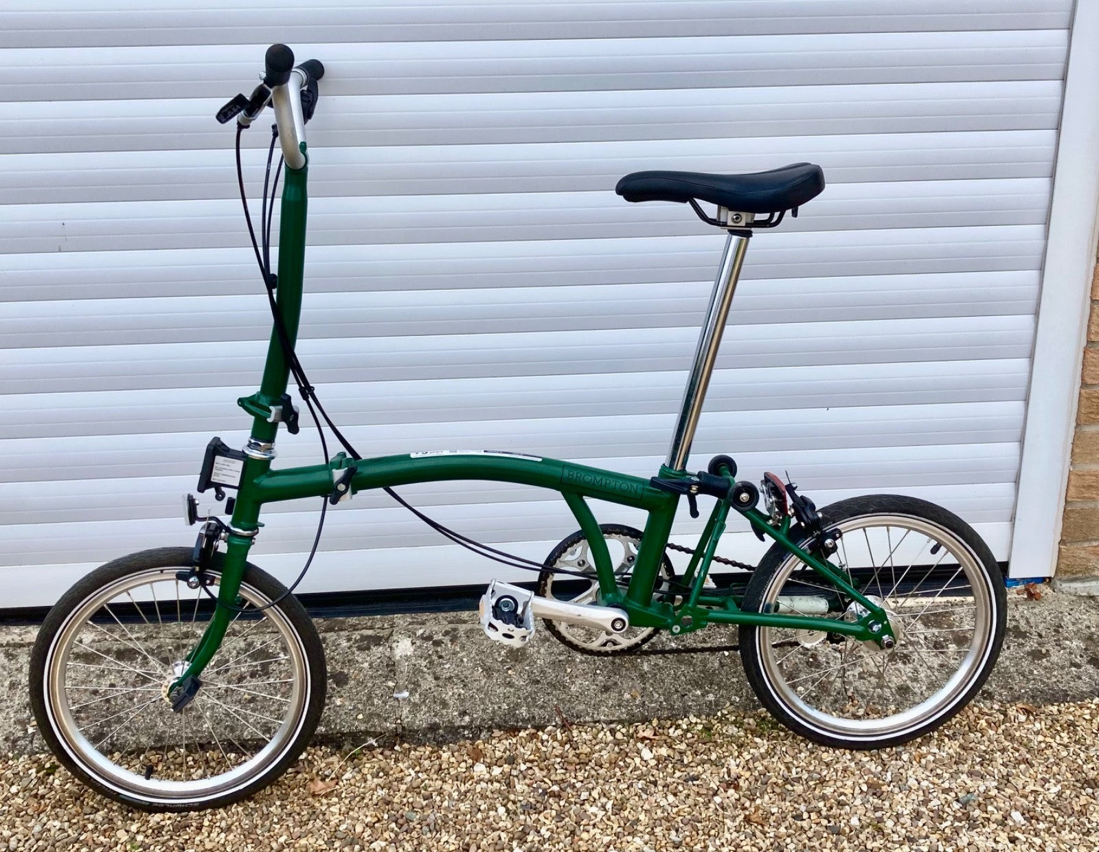 2023 Brompton C line folding bike, 3-speed, green,  with 4-roller transit bag