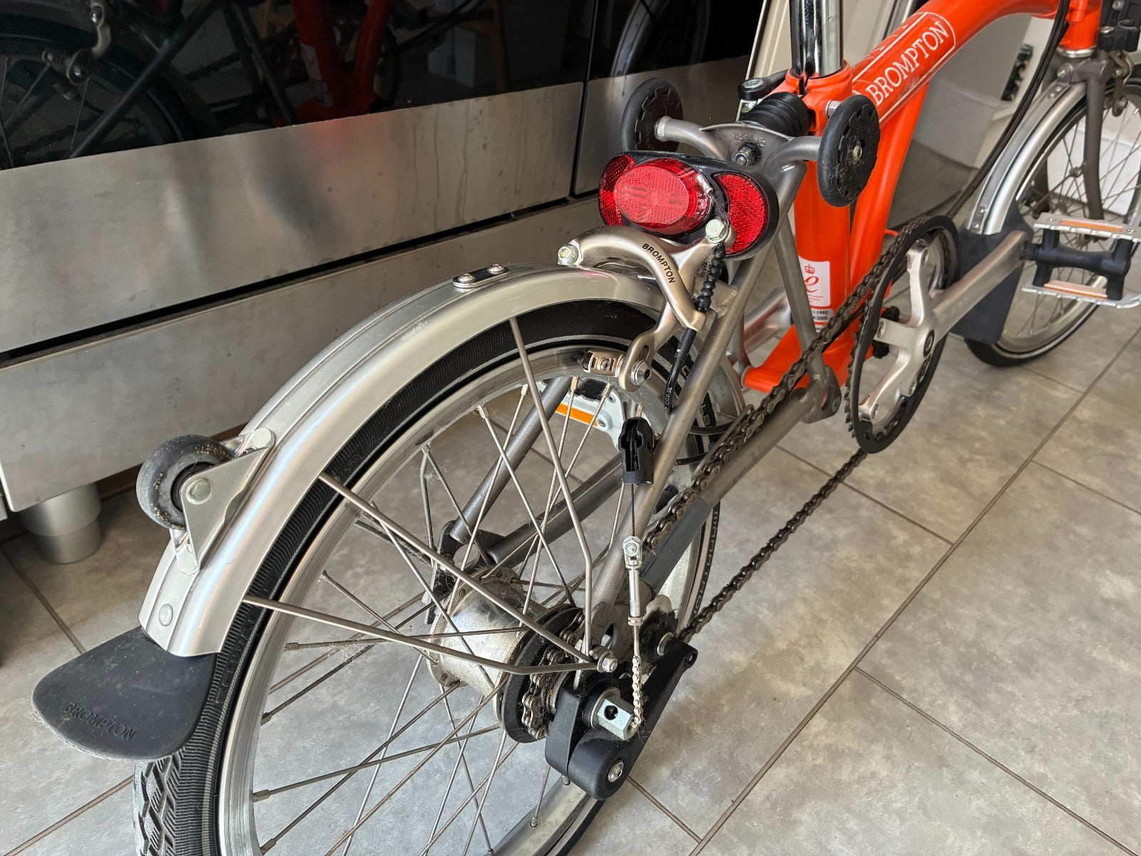 Brompton M3L Superlight Titanium  3 Speed in orange with front Ortlieb bag