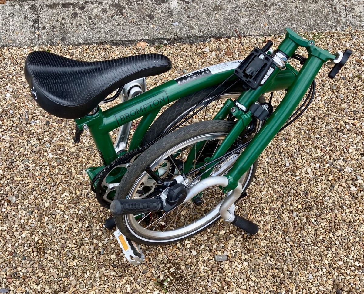2023 Brompton C line folding bike, 3-speed, green,  with 4-roller transit bag