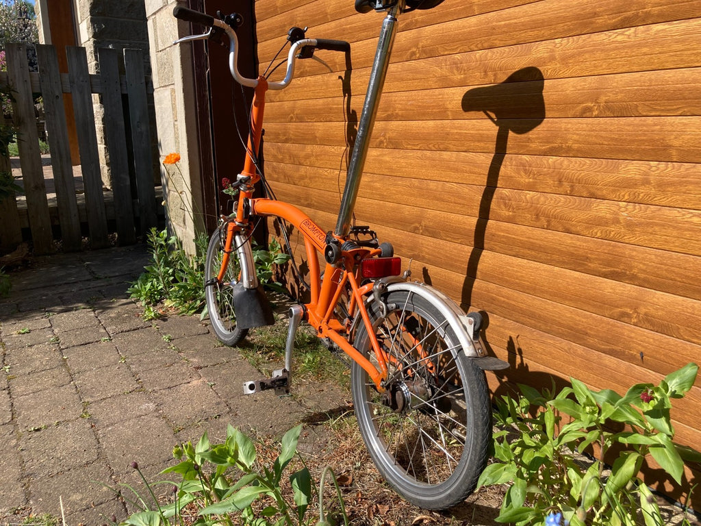 Classic Brompton 6-speed C-line folding bike in orange with long seatpost