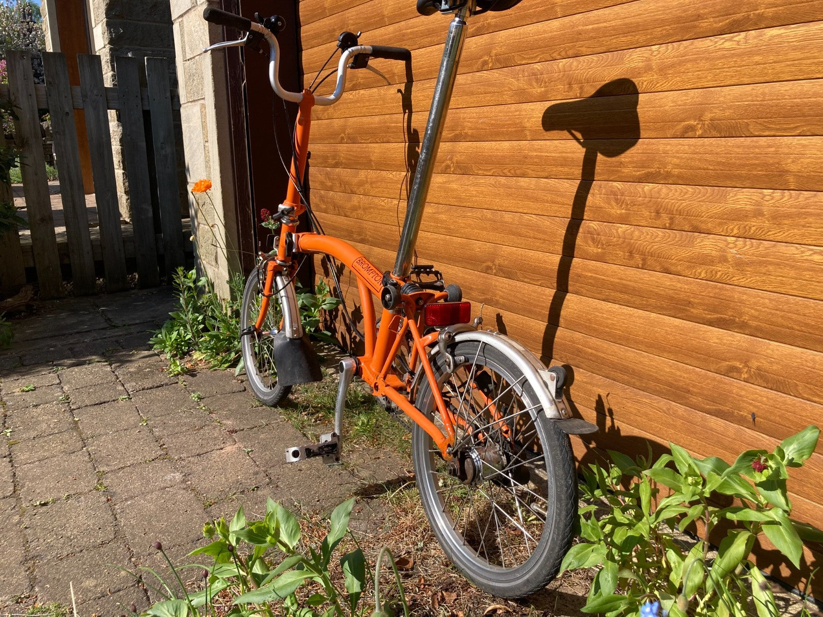 Classic Brompton 6-speed C-line folding bike in orange with long seatpost