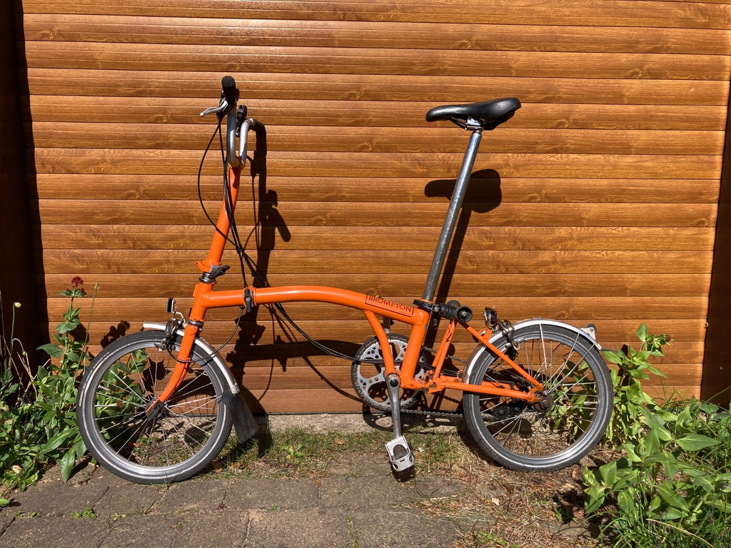 Classic Brompton 6-speed C-line folding bike in orange with long seatpost