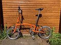 Classic Brompton 6-speed C-line folding bike in orange with long seatpost