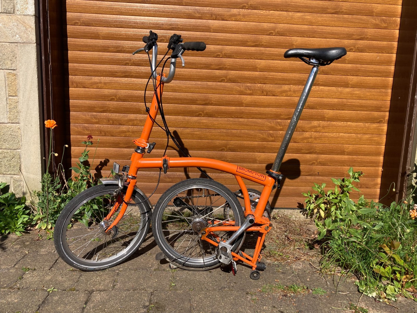 Classic Brompton 6-speed C-line folding bike in orange with long seatpost