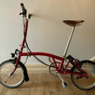 A bespoke Brompton C Line Folding Bike with Black Mudguards. Ruby red.